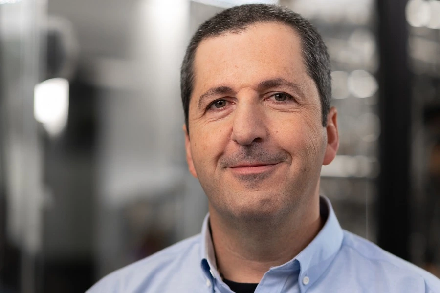 middle aged man in blue formal shirt smiling